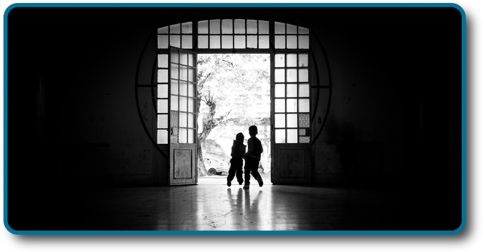 A photograph shows two children running outside through an open doorway.